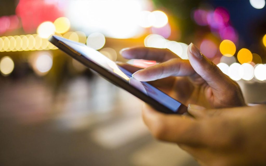 A person holding a phone using DEWA app for connection activation