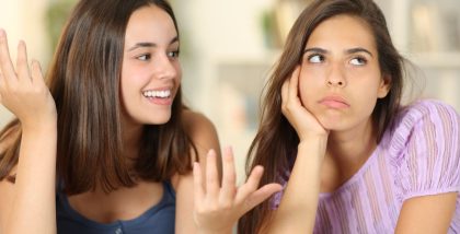 Two women having a conversation, with one appearing uninterested.