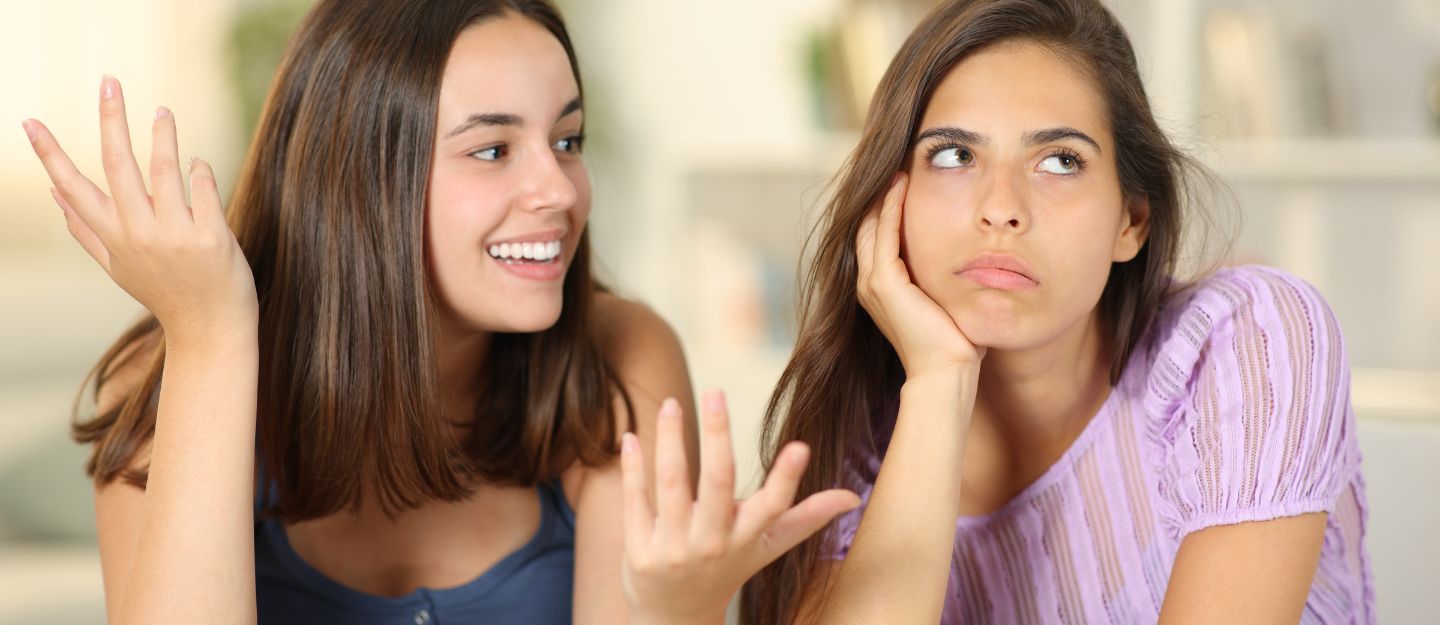 Two women having a conversation, with one appearing uninterested.