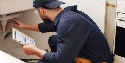 Plumber inspecting kitchen sink pipes