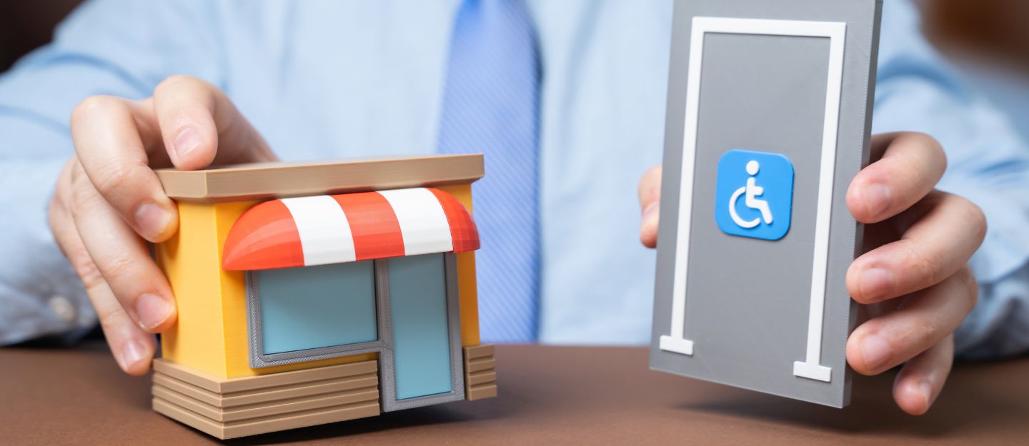 Person holding a shop model and an accessibility symbol.