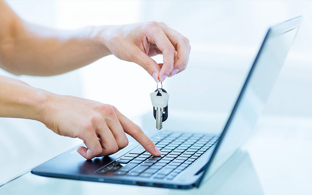 شخص بيده مفتاح أمام اللابتوب