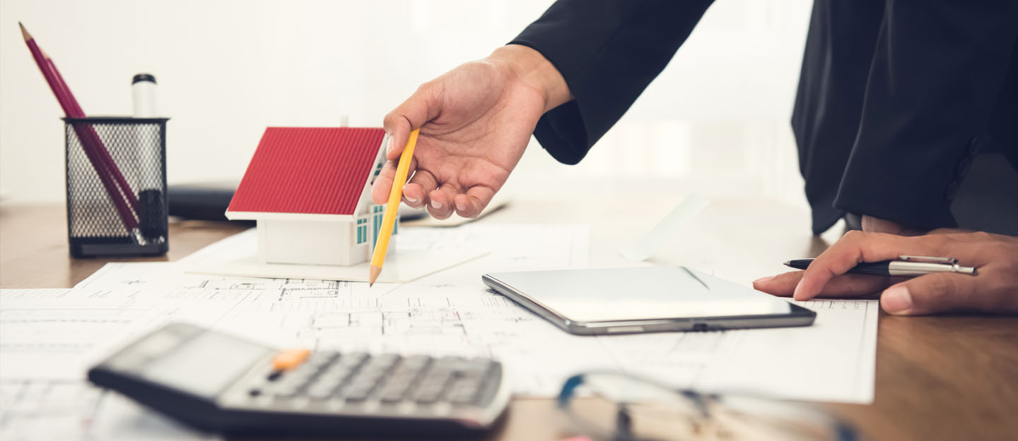 شخص يشير لآخر بيده نحو أوراق عقارية