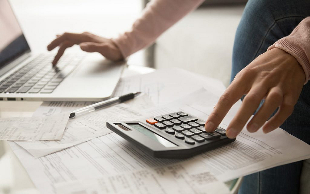 سيدة تستعمل آلة حاسبة ولاب توب