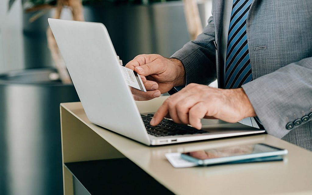 شاب يدخل معلومات البطاقة الائتمانية على اللابتوب