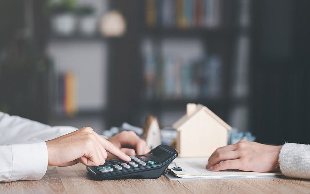 أشخاص يستخدمون آلة حسابة لحساب أجرة عقار