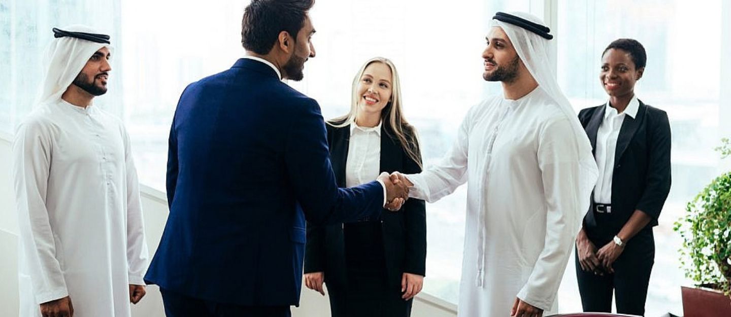 Real estate professionals shaking hands during a business meeting.