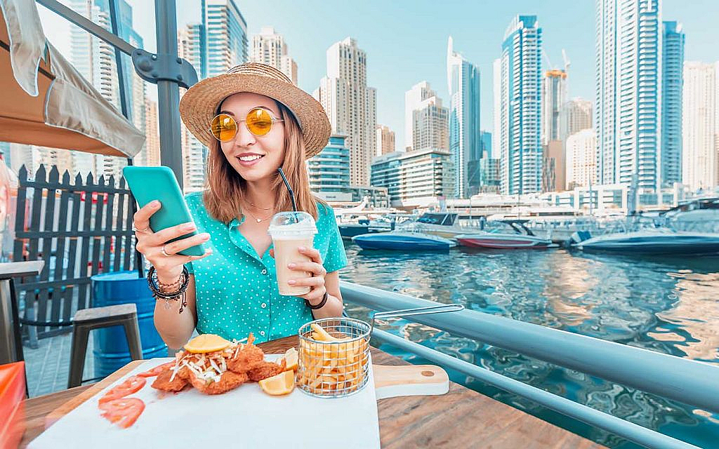 A girl enjoying food at an outdoor cafe in Dubai Marina