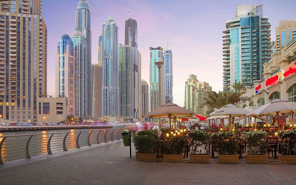 an outdoor cafe in a dubai area near water