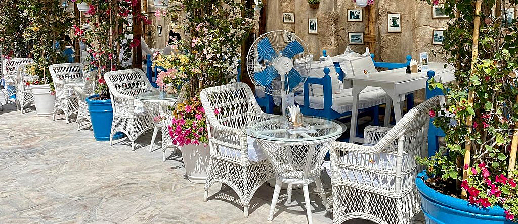 An outdoor seating in a cafe with plants around