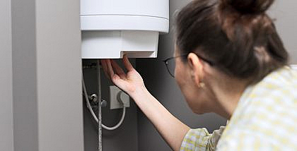 سيدة تفحص سخان المياه