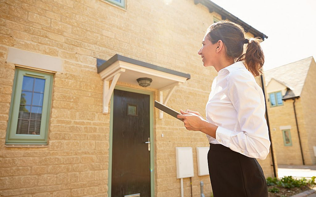 a woman surveying a house