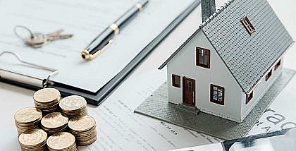 مجسم منزل مع واوراق وعملات معدنية