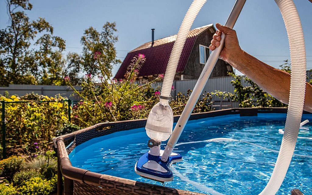 A person cleaning the swimming pool