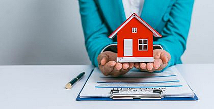 شخص يحمل مجسم منزل