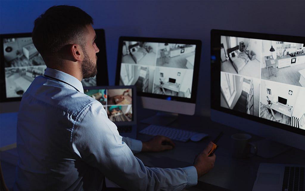 رجل أمن يراقب مبنى باستخدام الكاميرات