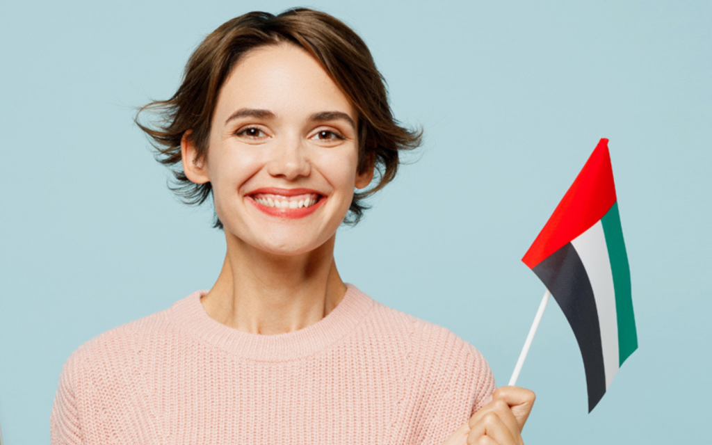 فتاة تمسك بعلم الإمارات