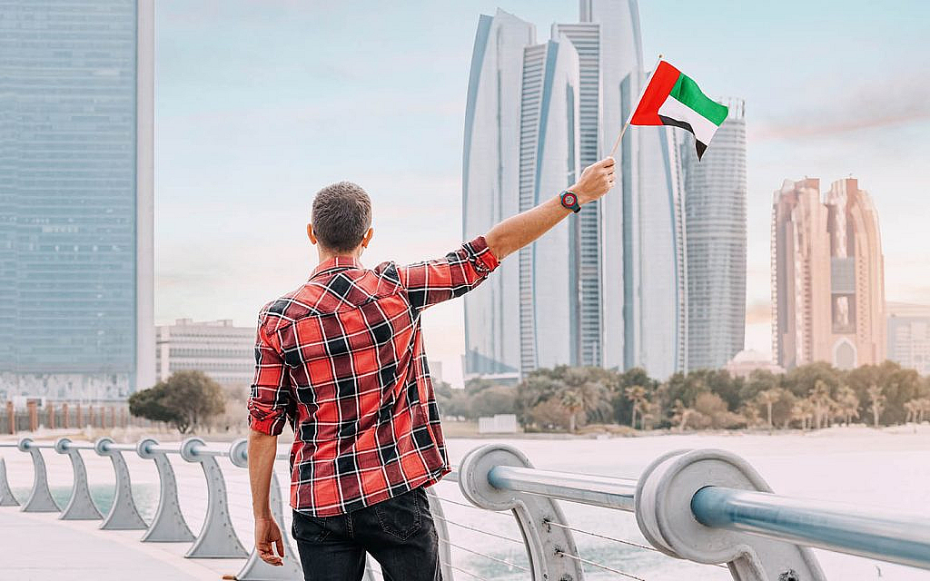 شاب يمسك بعلم الإمارات