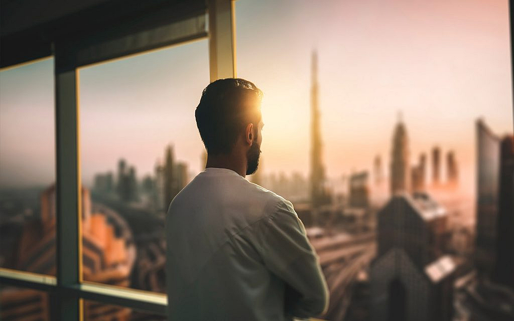 شخص ينظر من نافذة مُطلة في دبي