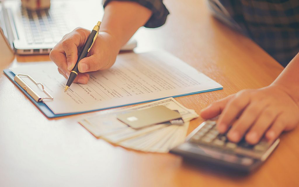 آلة حاسبة وعقد ونقود وبطاقة ائتمان