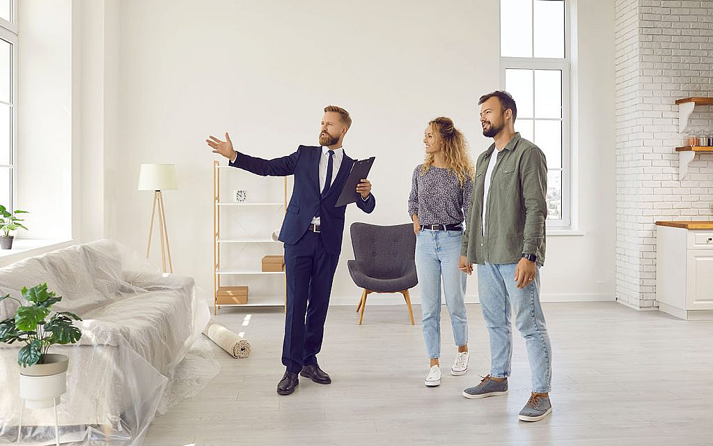 زوجين مع وكيل عقاري في أحد المنازل