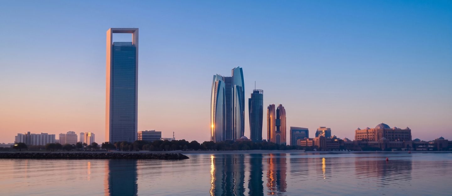 Abu Dhabi skyline reflection on water during a serene sunset.
