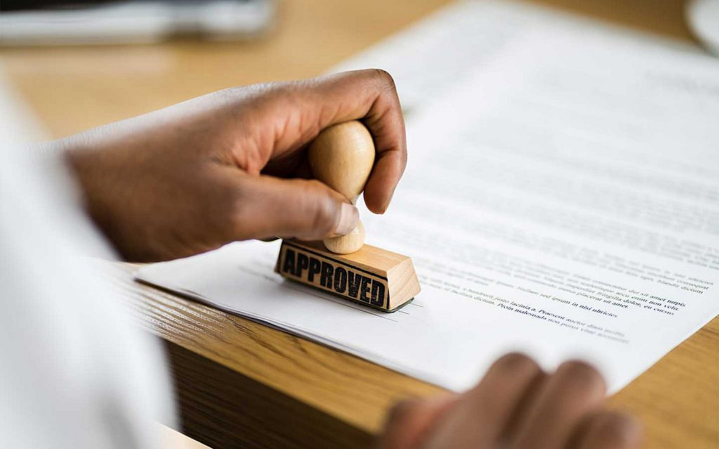 شخص يختم بختم موافقة على أوراق