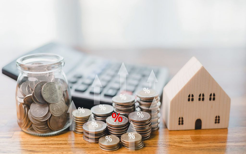A money jar, house model, coins and a calculator
