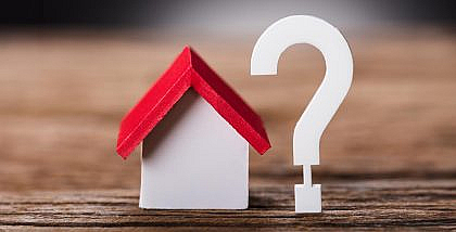 مجسم منزل خشبي وعلامة استفهام