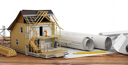 مجسم منزل صغير قيد الإنشاء ومخططات هندسية