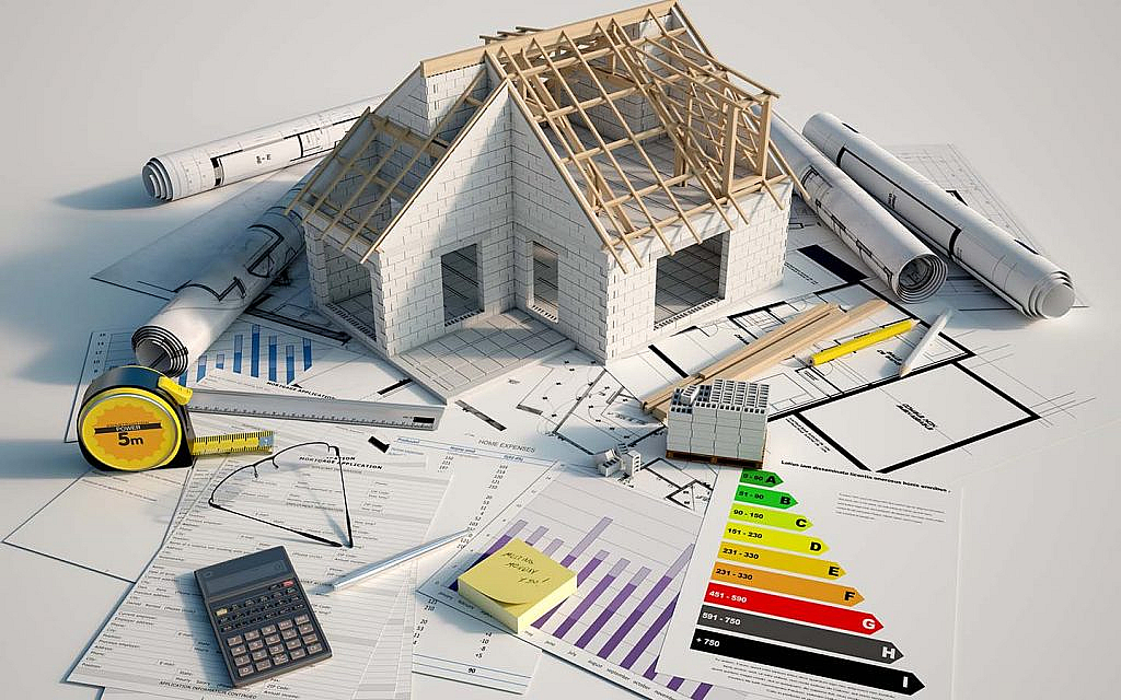 مجسم منزل قيد البناء ومخططات وأدوات هندسية