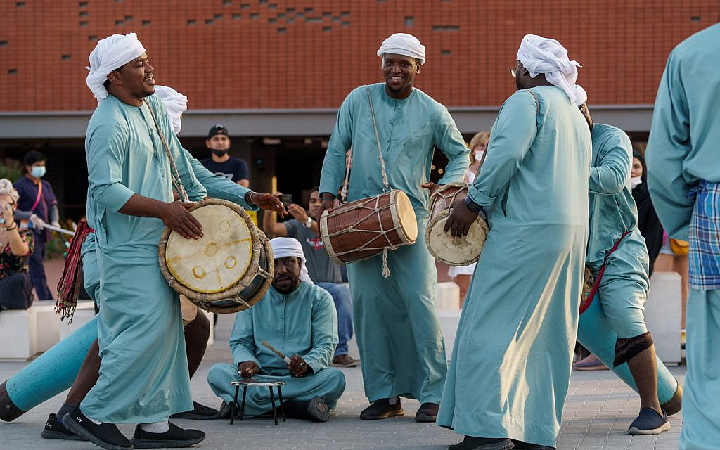 مجموعة من الرجال يرتدون ملابس تقليدية إماراتية يحملون طبول
