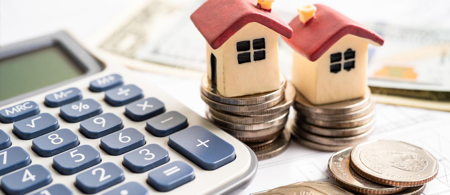 مجسمات منازل وآلة حاسبة وعملات نقدية