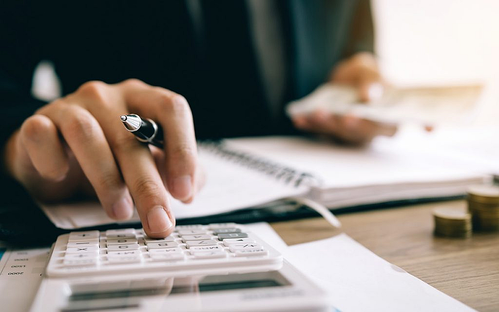 شخص يقوم بحسابات على آلة حاسبة
