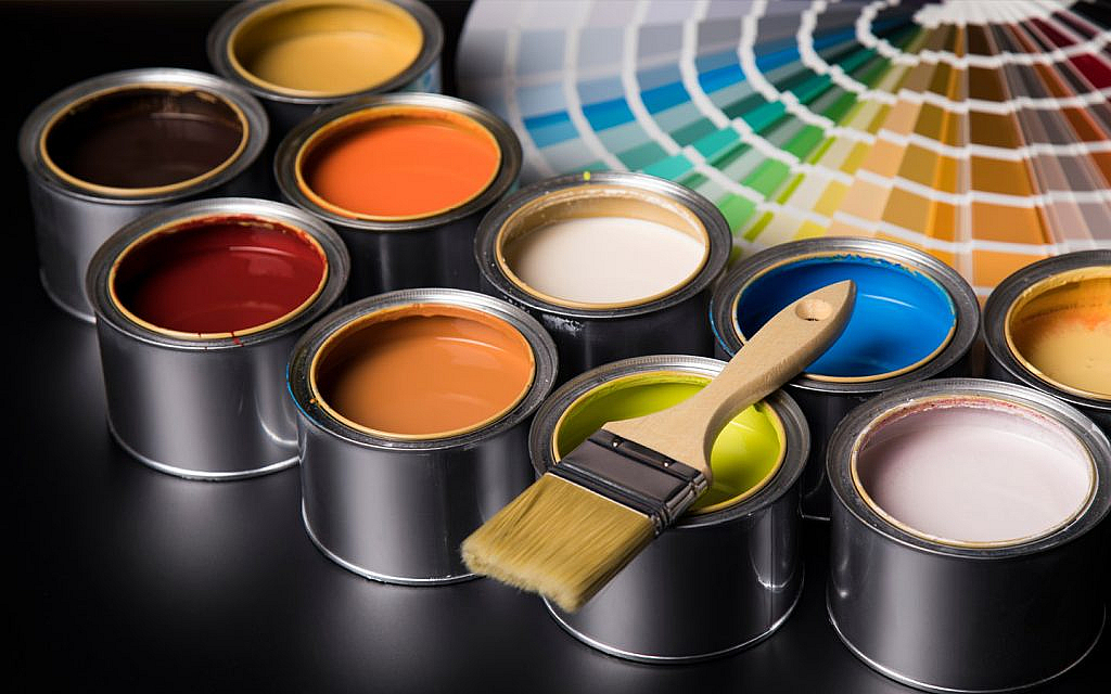 مجموعة كبيرة من علب الدهان وفرشاة وعينات ألوان