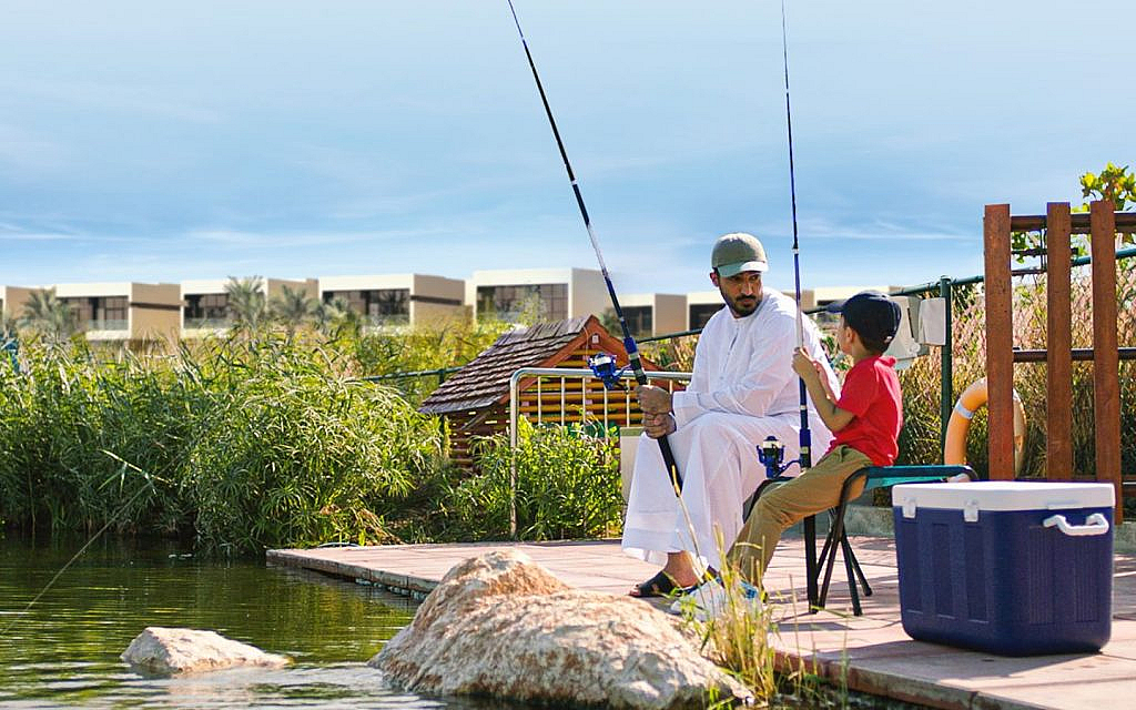 Father and son fishing near villas in DAMAC Hills 2