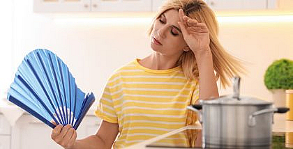 سيدة تعاني من الحرارة العالية للجو