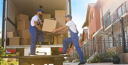 عمال نقل أثاث يضعون الأثاث في شاحنة