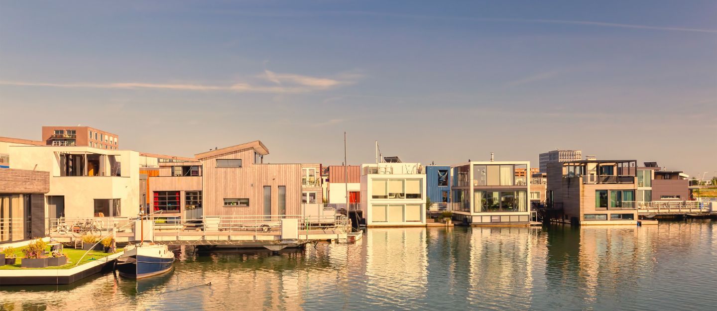 A row of modern floating villas on a calm body of water under a clear sky