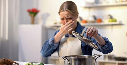 امرأة منزعجة من رائحة طعام
