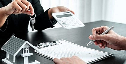 A landlord offering keys and a calculator to a tenant signing a contract, following tenant screening questions.