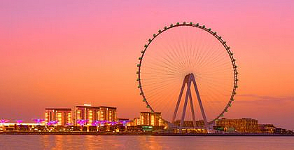 Ain Dubai Ferris wheel and illuminated buildings at sunset, visible from Areas to Rent Villas With Ain Dubai View.
