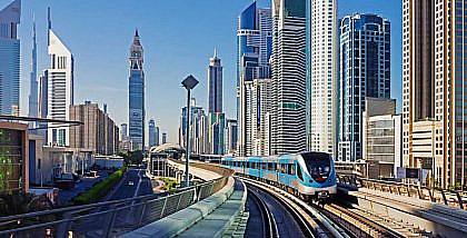 Dubai Metro train on an elevated track amidst skyscrapers, illustrating living near a metro station.