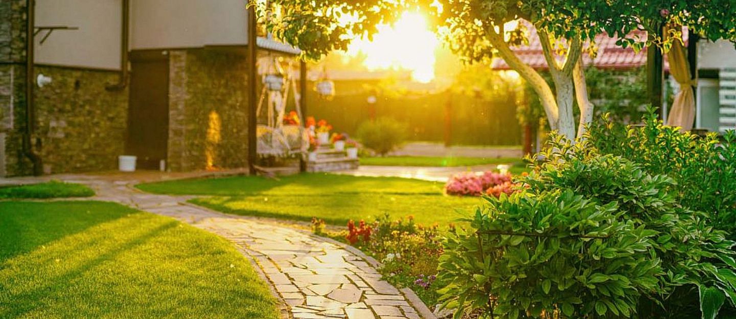 Lush garden with a path and flowers, maintained by Landscaping Companies in Sharjah.