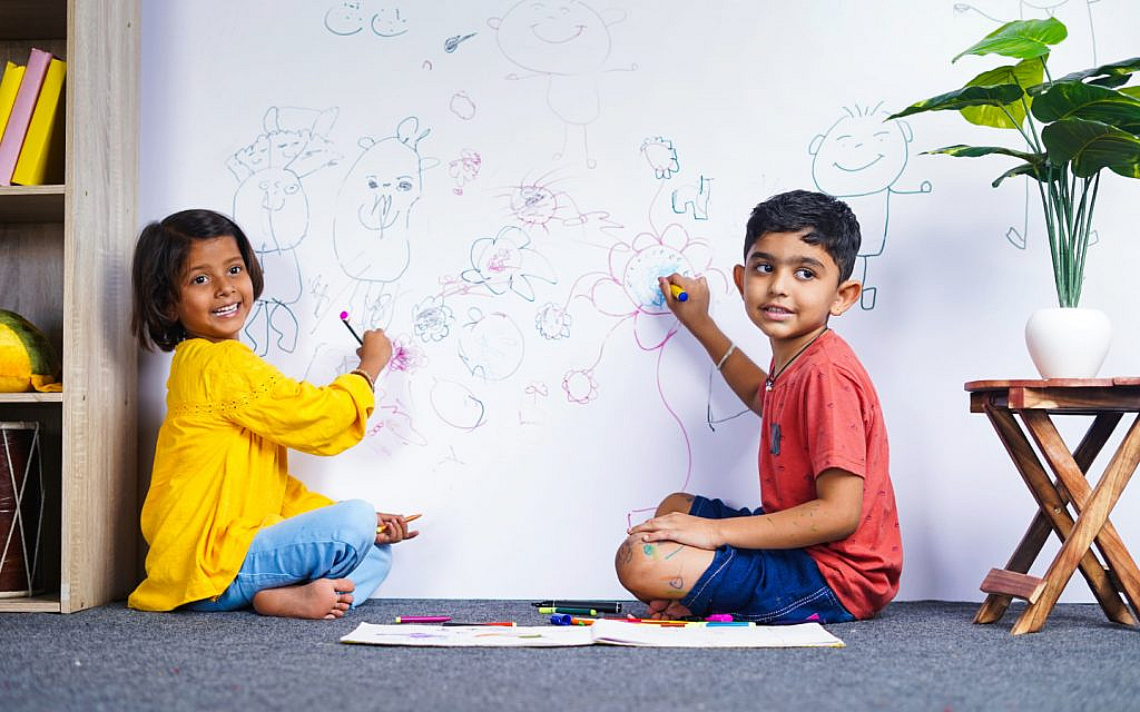 أطفال يرسمون على الحائط