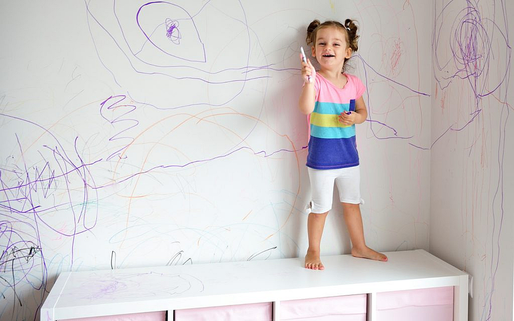 طفلة ترسم بألوان على الجدران