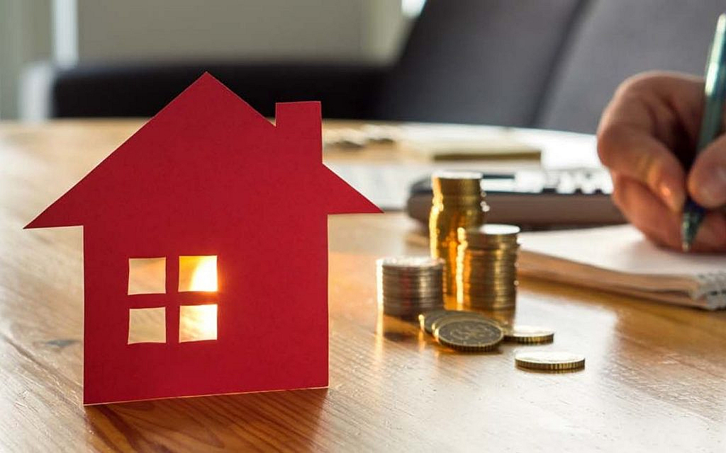 عملات نقدية وورقة صغيرة بتصميم منزل