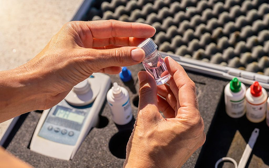 عامل يخلط مواد للعناية بمياه المسبح