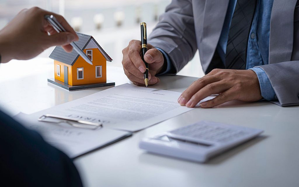 مجسم منزل وآلة حاسبة وأوراق