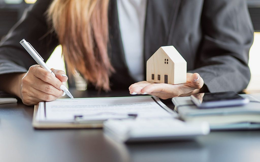 سيدة تمسك مجسم منزل